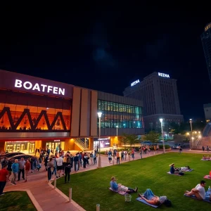 Crowd gathered outside a downtown arena and amphitheatre lawn in Tampa at night with bright stage lights