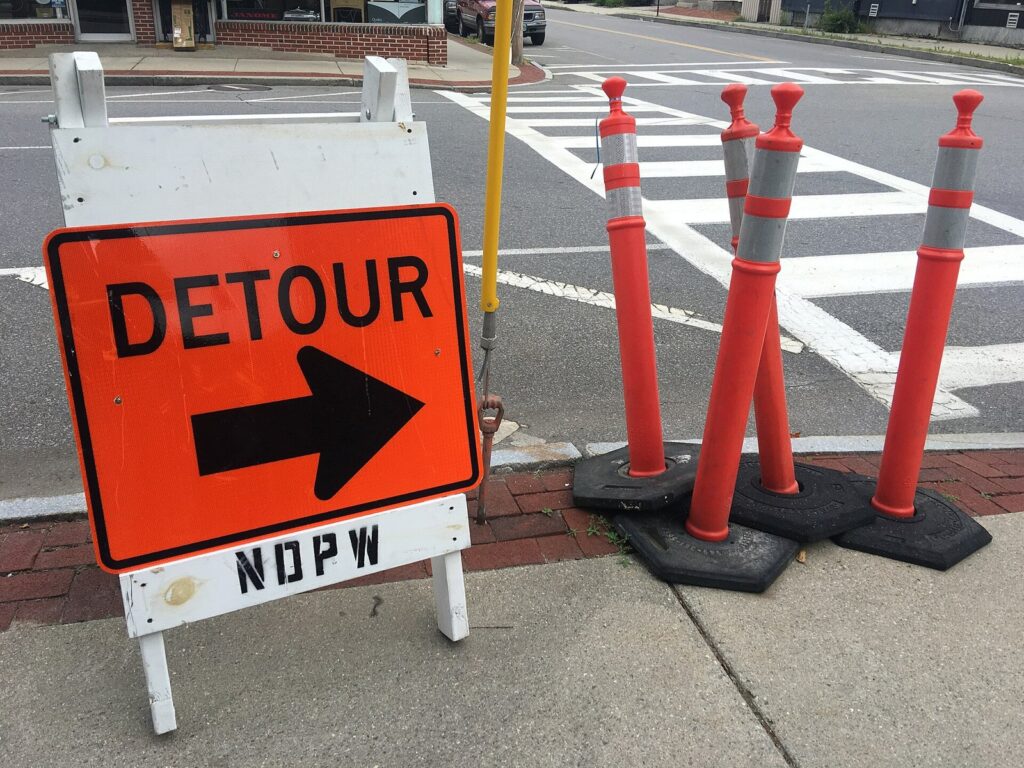 Orange detour sign and traffic posts